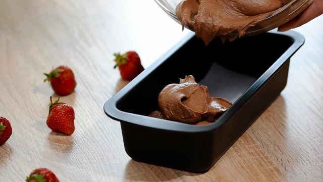 Pouring cake mix into baking tin.