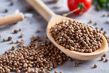 Coriander in wooden spoon with clipping path on white textured background, close-up, shallow depth of field.