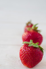 Strawberries ripe on a white wooden background. Copy space. Healthy lifestyle concept