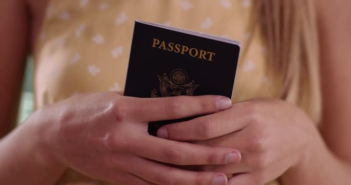 Close-up of young female standing and holding US passport while on vacation, Tight shot of American passport held by young Caucasian woman who is traveling around, 4k