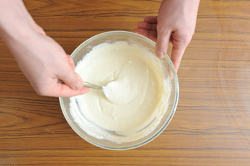 Prepare the dough for a homemade cake, hand knead the dough in a bowl