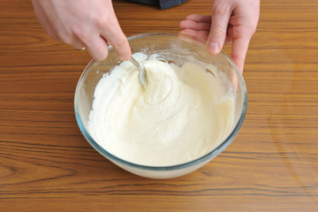 Prepare the dough for a homemade cake, hand knead the dough in a bowl