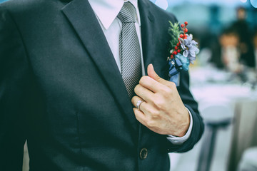 The married man holding collar of his suit jacket.