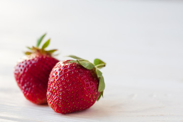 Strawberries ripe on a white wooden background. Copy space. Healthy lifestyle concept