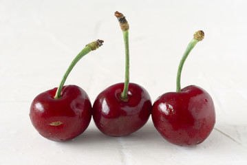 ripe cherries on white textured background