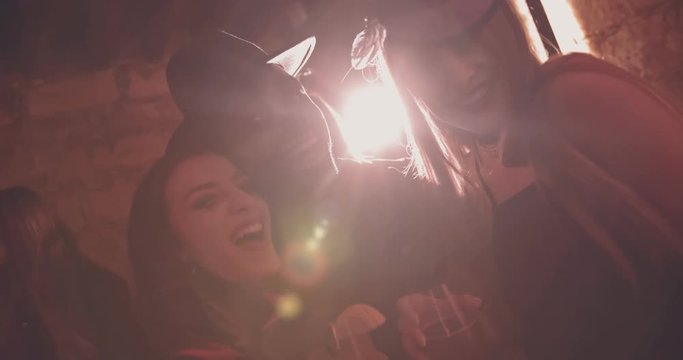 Young multi-ethnic friends in Halloween costumes drinking and having fun