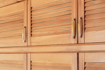 Modern wooden cabinet in classic rustic style. Details of wardrobe case with shutter plank doors....