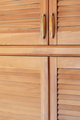 Modern wooden cabinet in classic rustic style. Details of wardrobe case with shutter plank doors. Country house interior