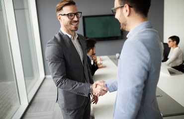 Two confident business man shaking hands during a meeting in the office