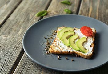 Plate with delicious toast on wooden table