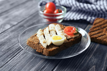 Plate with delicious toast on wooden table