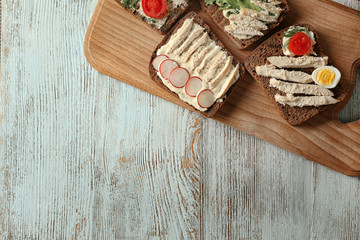 Composition with delicious toasts on wooden table