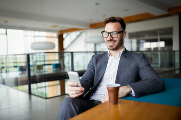 Obraz premium Business man in a business suit and a cup of coffee in a office