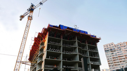 Crane near building under construction. Construction site.