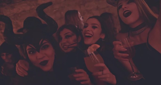 Young women drinking and having fun at nightclub Halloween party