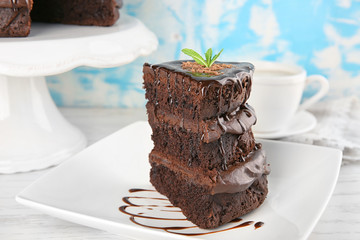 Plate with piece of chocolate cake on wooden table