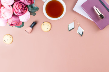 Flat lay home office desk. Feminine workspace with diary, flowers, sweets, fashion accessories. Fashion blogger concept.