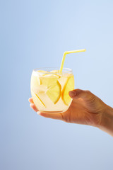 cropped shot of woman holding glass of lemonade isolated on blue