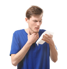 Young man with nose wiper on white background. Allergy concept