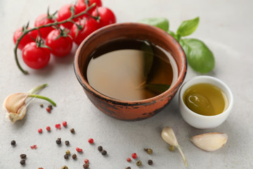 Bowls of fresh olive oil with vegetables and spices on table