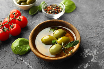 Bowl of fresh olive oil and tomatoes on table