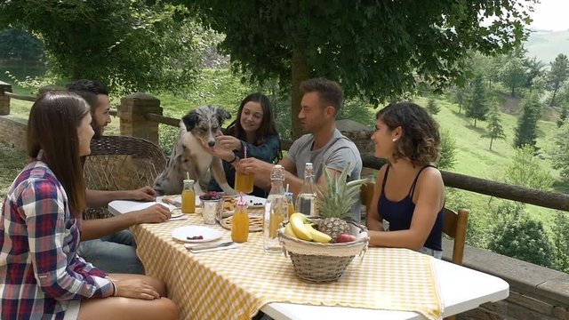 group of friends making picnic in the countryside