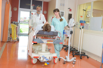 workers moving patients in hospital