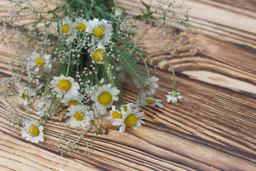 chamomile meadow and Gypsophila ear with a close-up of a bouquet on a wooden background