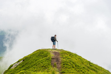 man standing on the peak of the mountain