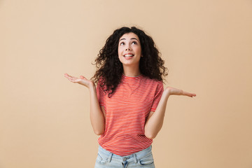 Emotional young woman isolated over beige wall