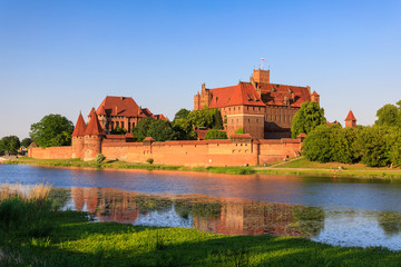 Fototapeta na wymiar Teutonic Castle of Malbork reflected in water