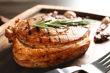 Wooden board with tasty grilled steak and rosemary, closeup