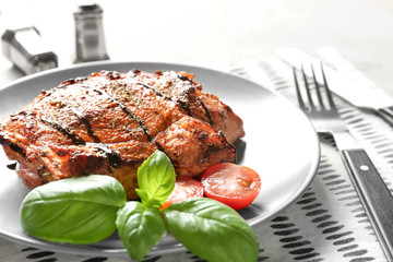 Plate with tasty grilled steak on table