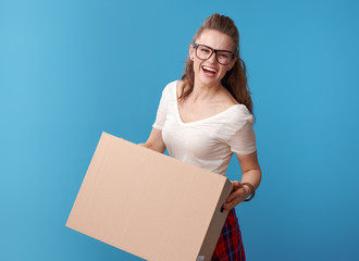 cheerful active hipster with cardboard box on blue