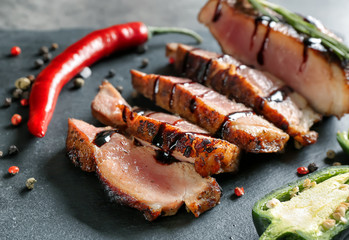 Sliced tasty steak with chili and spices on slate plate