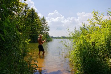 Fisherman in the lake during sunny day