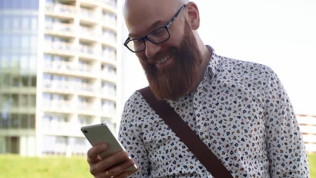 Cheerful businessman texting outdoors