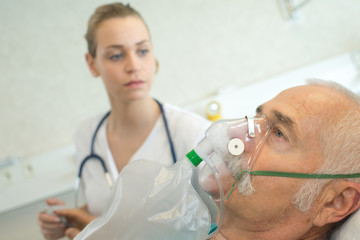 close-up of senior man using oxygen mask in clinic