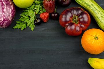 FRESH VEGTABLES AND FRUIT ON BLACK CHALK BACKGROUND