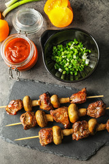 Barbecue skewers with juicy meat and mushrooms on slate plate