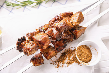 Barbecue skewers with juicy meat on table