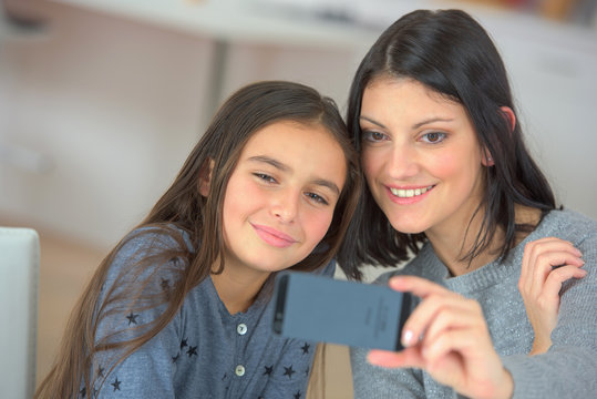 cute child and mother make selfie on new mobile phone