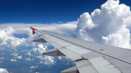 Obraz premium white clouds and blue sky as seen through window of an aircraft. travel and vacation concept