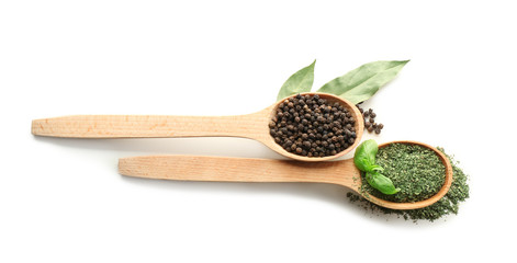 Wooden spoons with various spices on white background