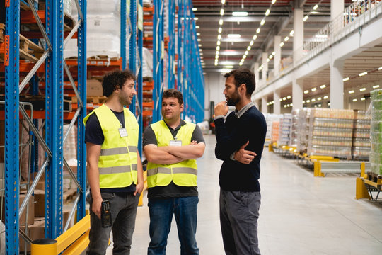 Manager talking with employees in warehouse