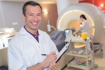happy male doctor with clipboard at the hospital