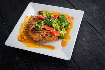 Tasty fried chicken meat with vegetables and lentils sauce on wooden background