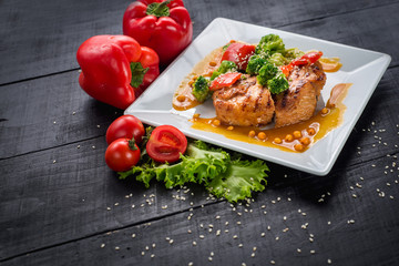 Tasty fried chicken meat with vegetables and lentils sauce on wooden background