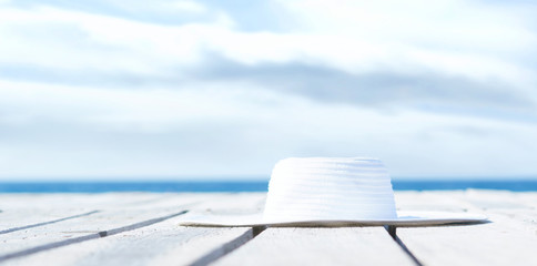 White summer hat on a wooden pier.