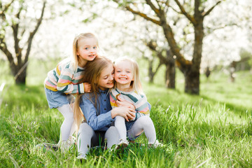 Naklejka na ściany i meble Three sister girls playing on the green park outdoor